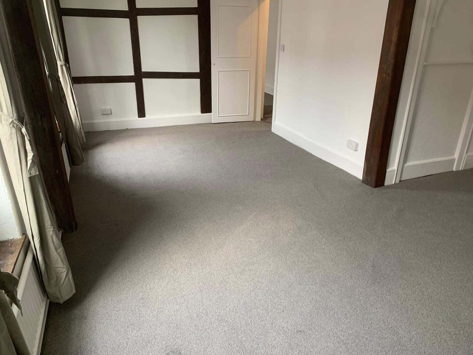 Grey carpet fitted in a beamed period room