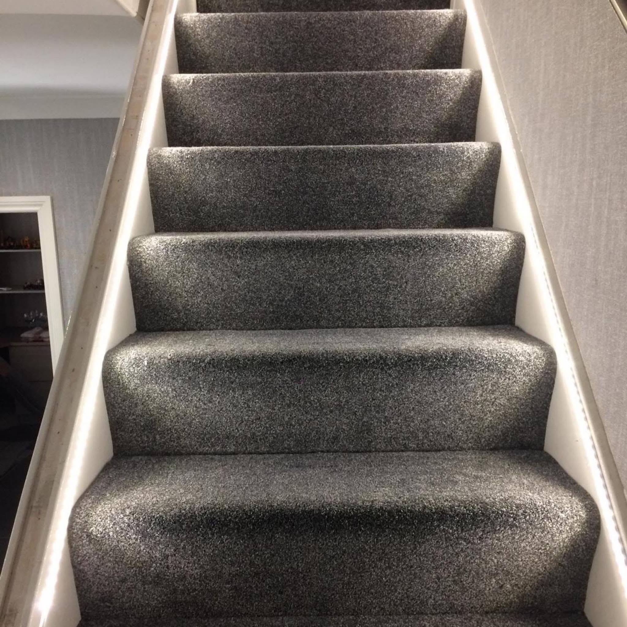 Grey sparkle-effect carpet fitted on a straight staircase with LED strip lighting