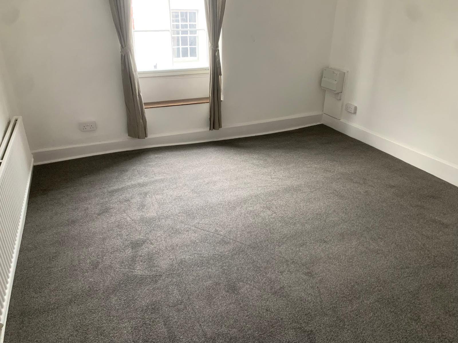 Grey carpet fitted in an empty bedroom