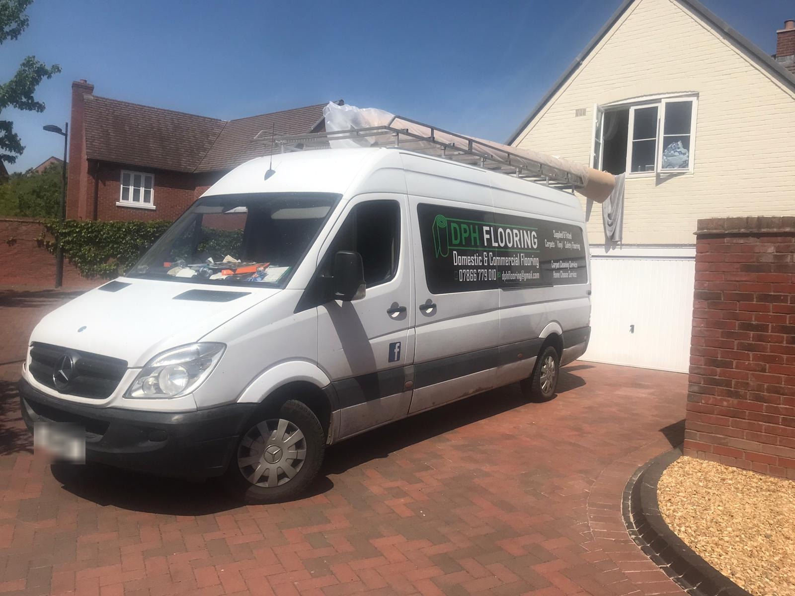 The DPH Flooring van on a driveway with a carpet roll on the roof rack