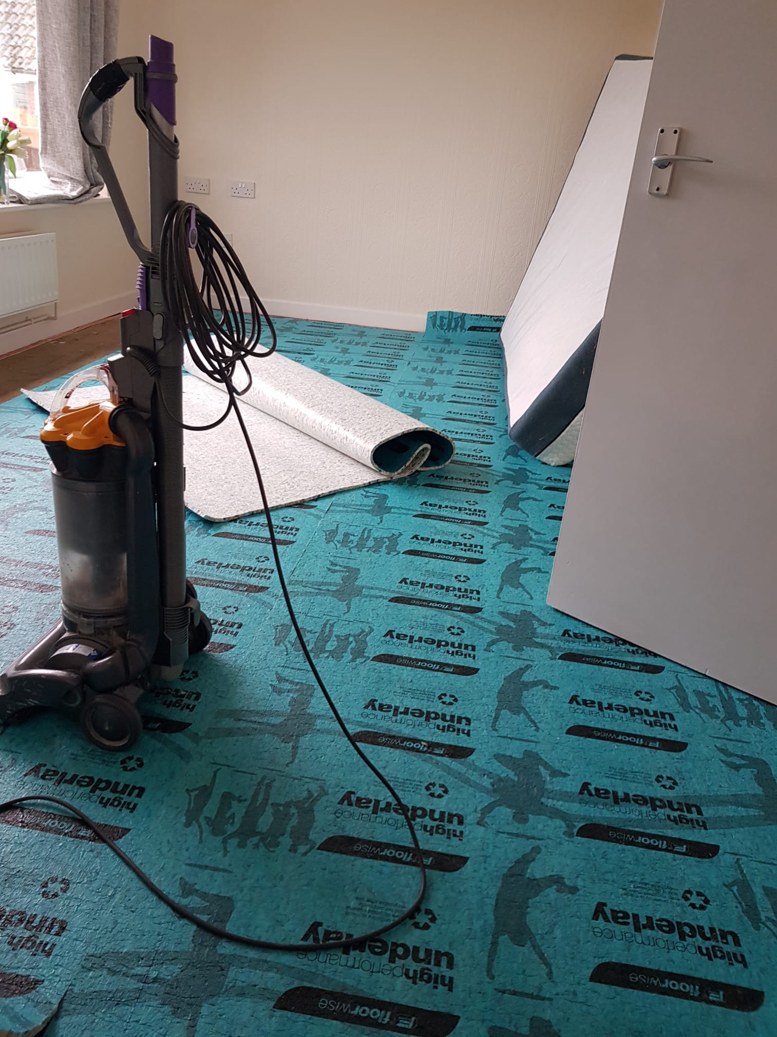 Underlay laid and a carpet roll ready to fit